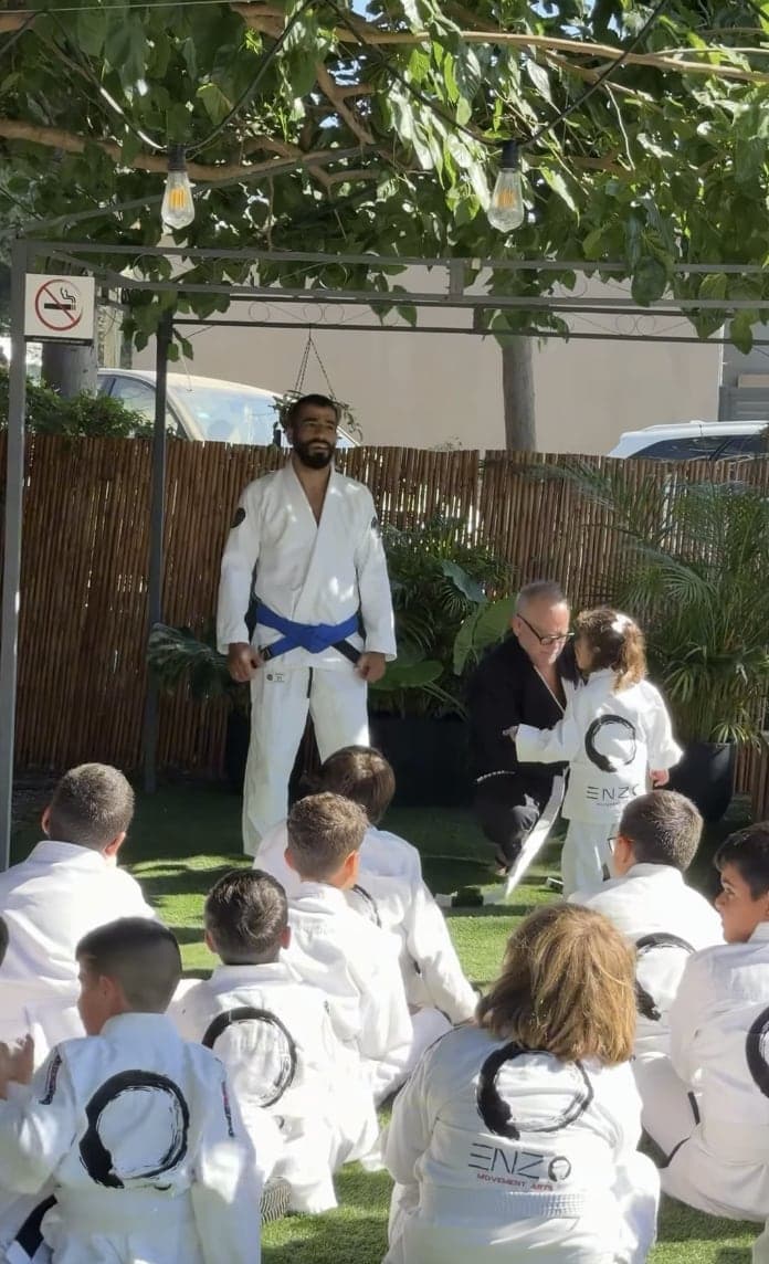 ילדים בחליפות ג׳יו ג׳יטסו עם המאמן